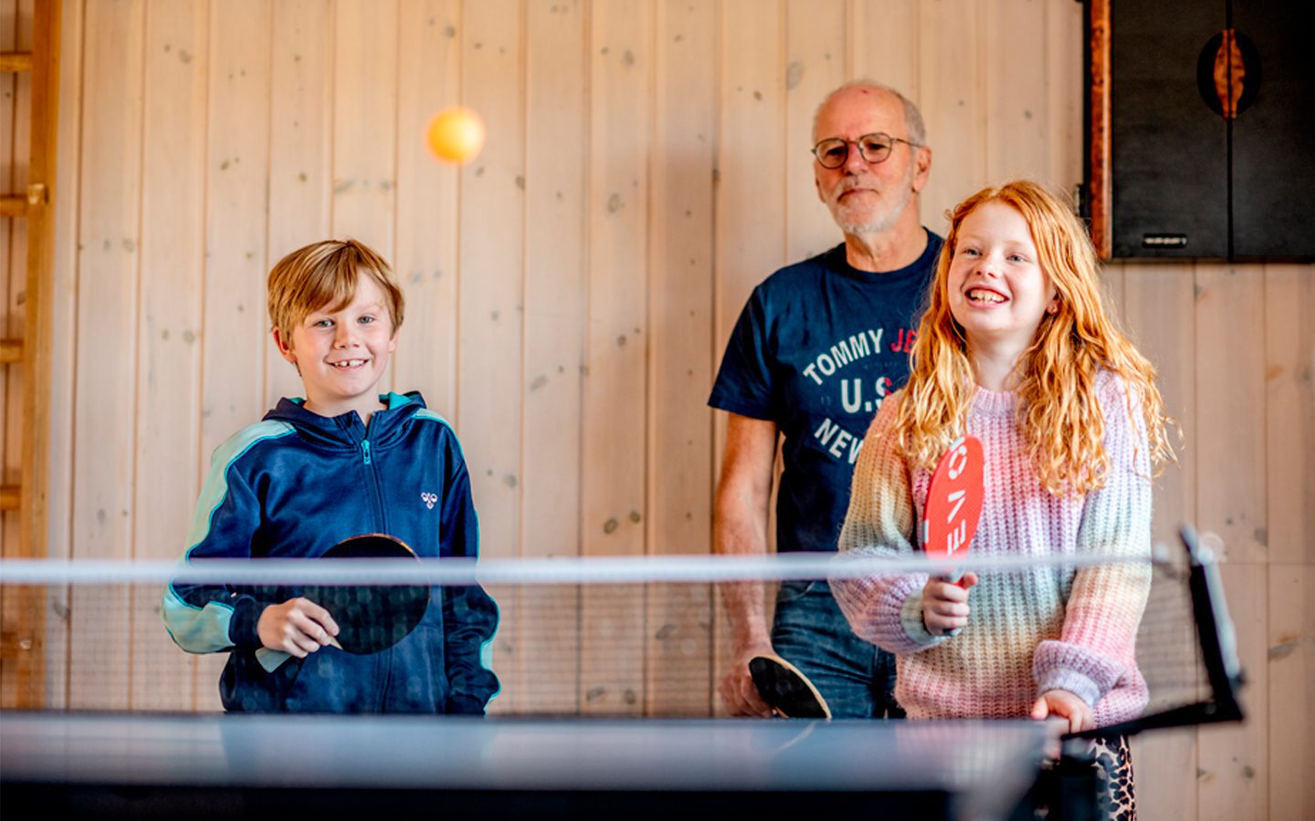 Familie spiller bordtennis i feriehuset