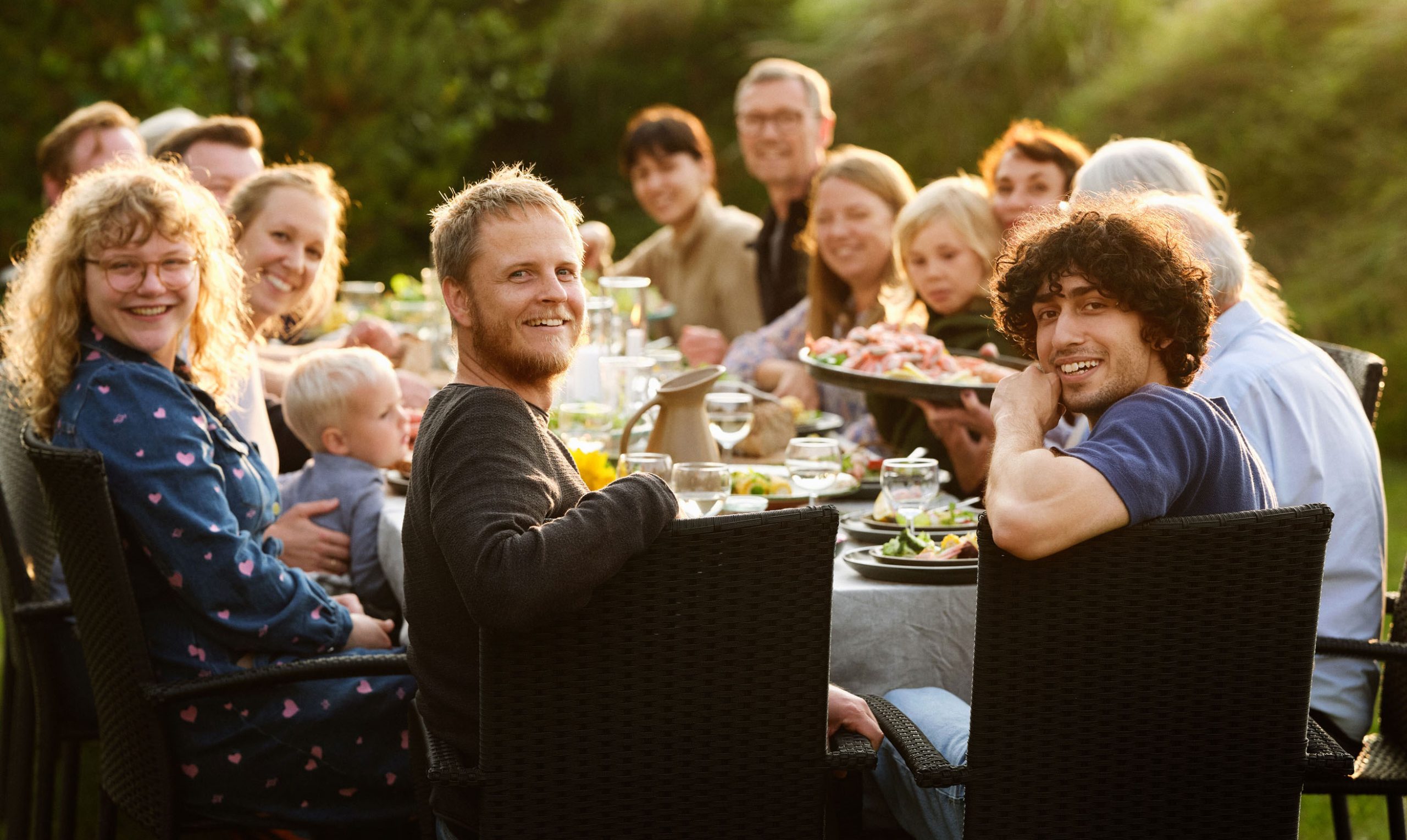 Familie samlet om bordet i haven